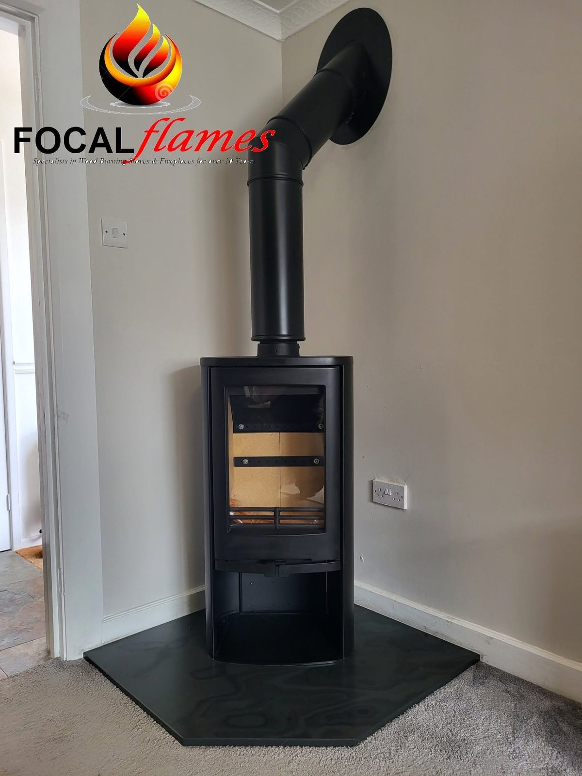A freestanding stove with its flue on a corner hearth