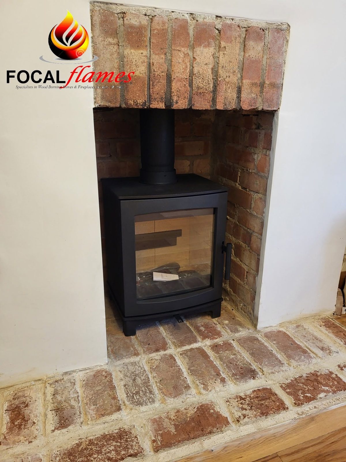 A stove in a brick recess on a brick hearth