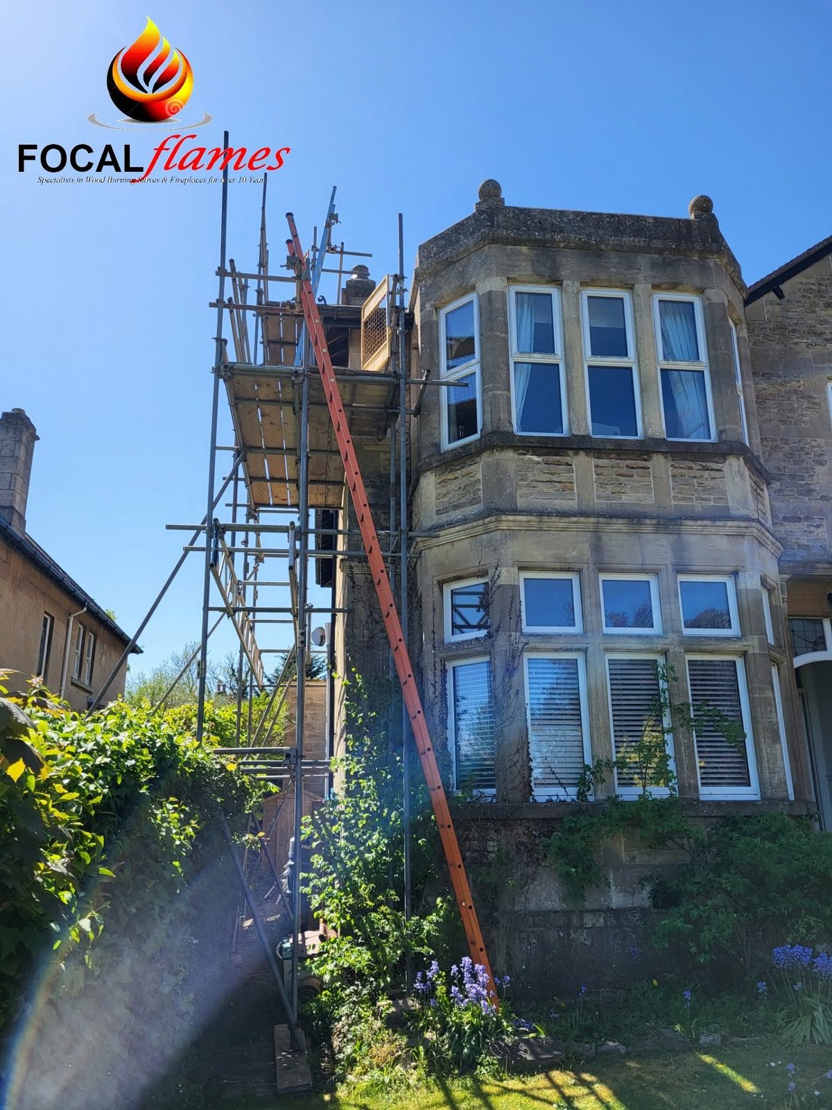 Ladders and scaffold up the front of a tall stone house