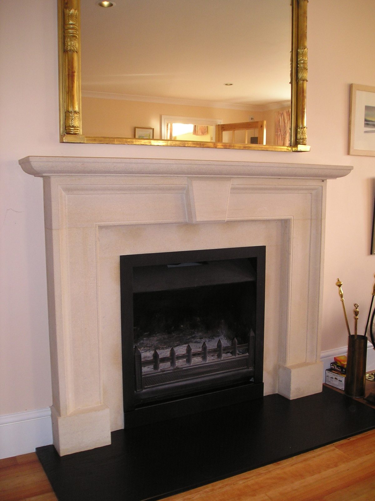 A cream stone surround with a black hearth and fire
