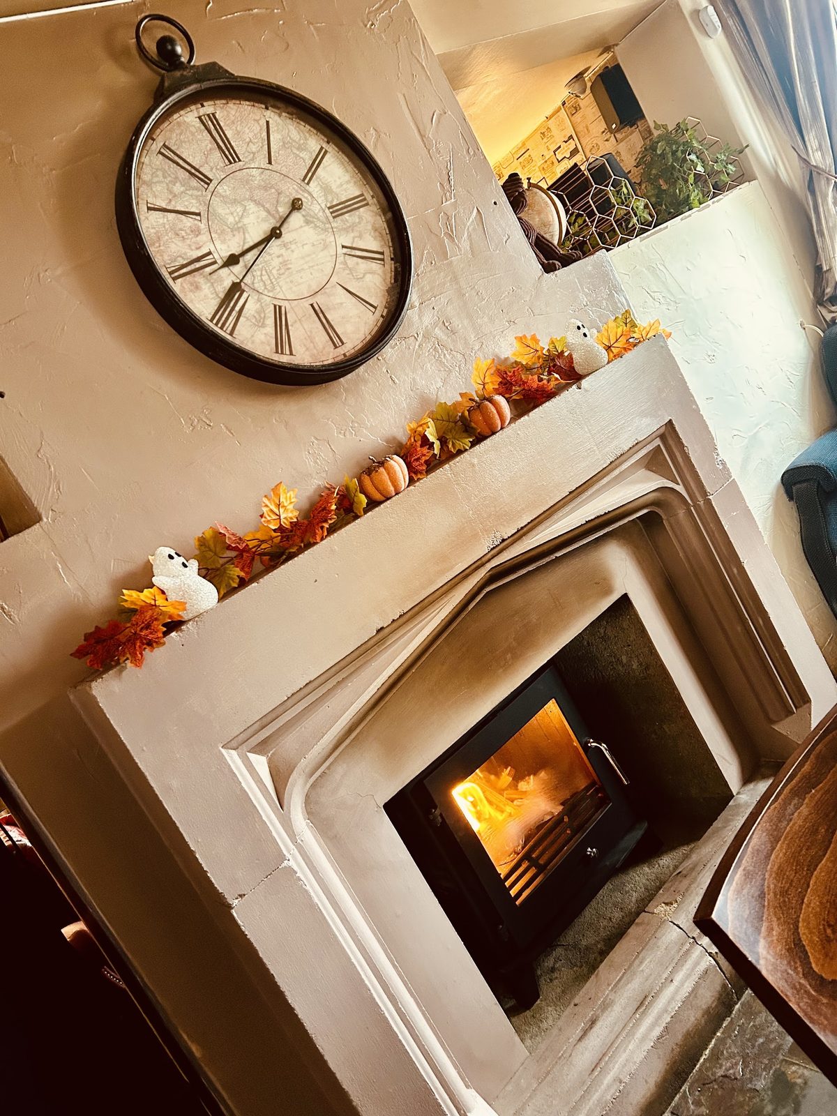 A customer's stone fireplace with stove and autumn garland