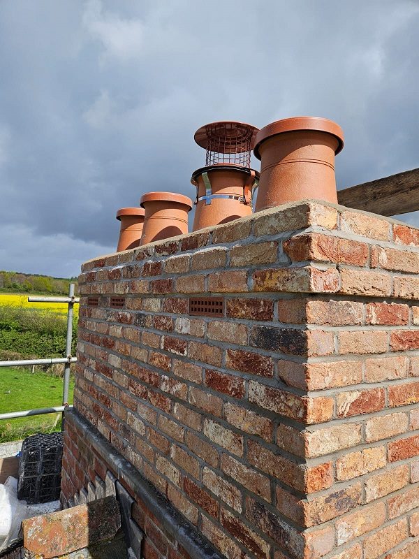 C caps on the redundant flues and a bird guard and rain cap on the active flue